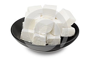Slices feta cheese in a black plate isolated on white background. Clipping path and full depth of field