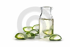 Slices of fresh aloe vera leaf and a bottle with the transparent