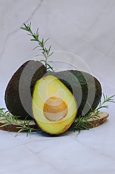 Slices of fresh avocado with herbs and lemons lies on the table on a blue plate. Flat lay. Top view. Healthy food concept. Diet