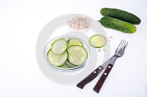 Slices of fresh cucumber in glass bowl.