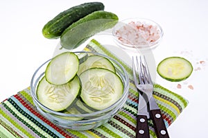 Slices of fresh cucumber in glass bowl.
