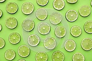 Slices of fresh juicy limes on green background