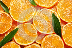 Slices of fresh ripe tangerines and leaves as background. Citrus fruit