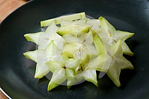 Slices of fresh star fruit. Carambola on a black plate.