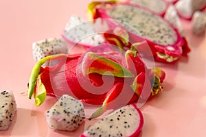 Slices of fresh white pitaya or dragon fruit on pink background, flat lay