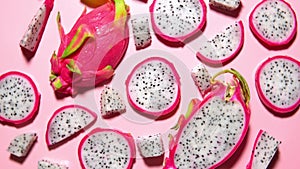 Slices of fresh white pitaya or dragon fruit on pink background, flat lay.