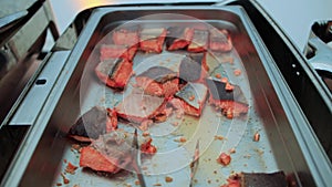 Slices of fried red fish with seasonings on a baking sheet, close-up, smorgasbord