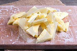 Slices of frozen pineapple on a cutting board on a table