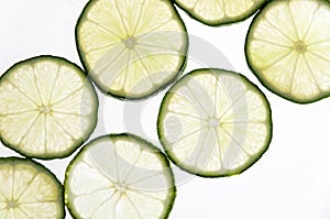 Slices of green fresh lime on a white background on the lumen.