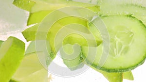 Slices of green juicy cucumber with lemon and star fruit in water. Texture of cooling refreshing summer's drink.