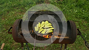 Slices of green pepper is frying on frying pan with oil in chargrill on nature.