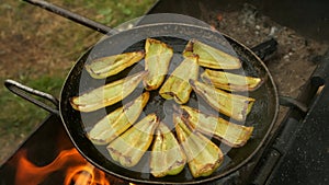 Slices of green pepper is frying on frying pan with oil in chargrill on nature.