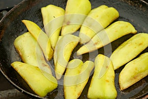 Slices of green pepper is frying on frying pan with oil in chargrill on nature.