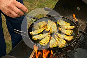 Slices of green pepper is frying on frying pan with oil in chargrill on nature.