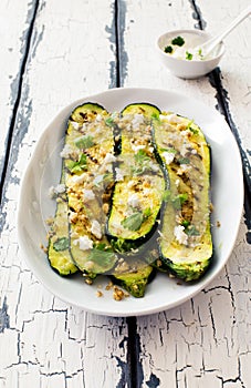 Slices of grilled zucchini with walnuts, soft cheese and greans close up