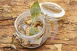 Slices of herring with spices in a glass jar