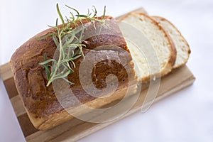 Slices of homemade white bread loaf on wood cutting board