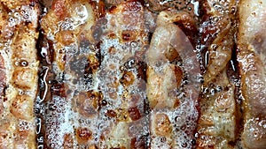 Slices of Hot Sizzling Bacon Cooking