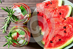 Slices of juicy watermelon and a refreshing cocktail with watermelon and rosemary with ice