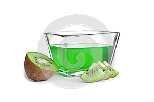 Slices of kiwi and tasty jelly dessert in glass bowl on white