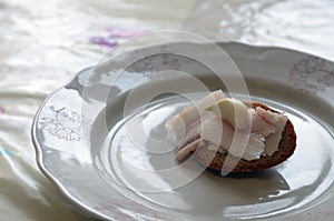 Slices Lard & Clove Garlic at small Hump Bread at Plate closeup