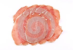 Slices of Lonzino, italian salumi, on white background.