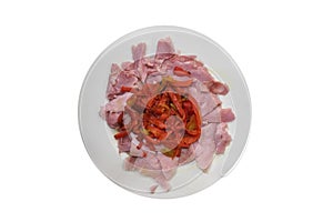 Slices of meat with red pepper on a plate isolated on white background