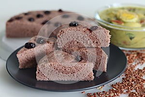 Slices of Navara rice vattayappam. Steamed rice cake made with a fermented batter of navara rice and coconut and steamed in a