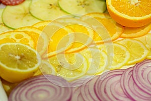 Slices of orange, lemon, apple and onion sliced into rings