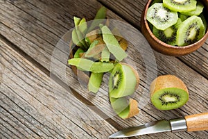 Slices and pealed kiwi on wooden table