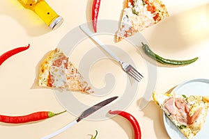 Slices of pizza, ingredients and cutlery on a white background. Top view