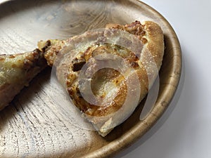 Slices of pizza on wooden plate on white background.