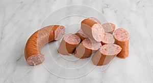 Slices of Polska Kielbasa on a gray marble cutting board. photo