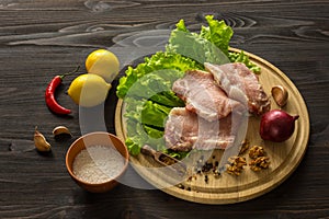 Slices of raw meat. Pork escalope on a wooden board.