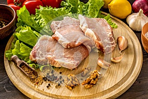 Slices of raw meat. Pork escalope on a wooden board.