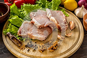 Slices of raw meat. Pork escalope on a wooden board.