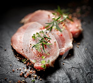 Slices of raw pork loin with the addition of aromatic herbs and spices