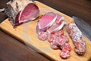 Slices of raw salted homemade ham or prosciutto and sausage