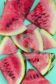 Slices of red watermelon on the green background. Top view