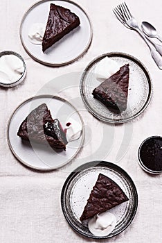 Slices of rich moist chocolate cherry cake. Homemade dark chocolate sweet brownies cakes with ice cream