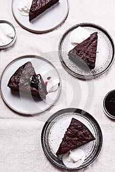 Slices of rich moist chocolate cherry cake. Homemade dark chocolate sweet brownies cakes with ice cream