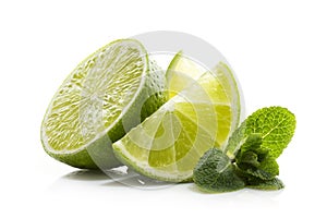 Slices of ripe and juicy lime with green mint leaves close-up