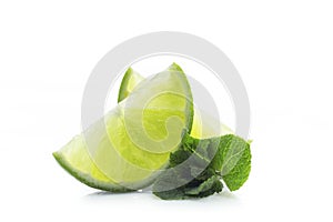 Slices of ripe and juicy lime with green mint leaves close-up