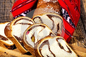 Slices of Romanian sponge cake with red traditional towel