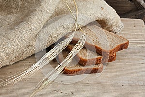 slices of rye bread and ears of corn on a wooden table