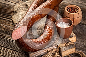 Slices of salami on a old wooden table. Sausages farm organic food. Food recipe background