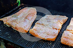 Slices of salmon cooking on the outdoor grille