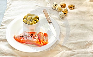 Slices of Salted Raw fish fillet with olive, quail eggs on white plate. Selection of good fat sources - healthy eating concept.