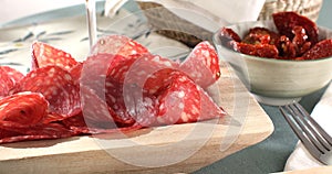 slices sausage salchichon on a plate. salami on a cutting board. cold cuts with bread and tomatoes.