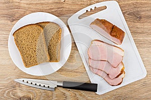 Slices of smoked gammon on cutting board, rye bread